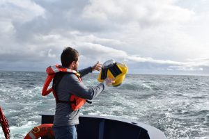 Andrew Reed tossing SOFAR spotter buoy