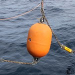 Four elements of the OOI Coastal Profiler mooring recovery system are strung out from the stern of the R/V Knorr during deployment operations. The "line pack" (left) has an acoustic release at its center and allows the line from the anchor to be brought to the surface by the lower Backup Recovery Buoyancy (BRB) module (second from left). The mooring riser release (second from right) is fired to separate the mooring from the anchor. The release is brought to the surface by the upper BRB (far right). (Photo Credit: Al Plueddemann, WHOI/CGSN)