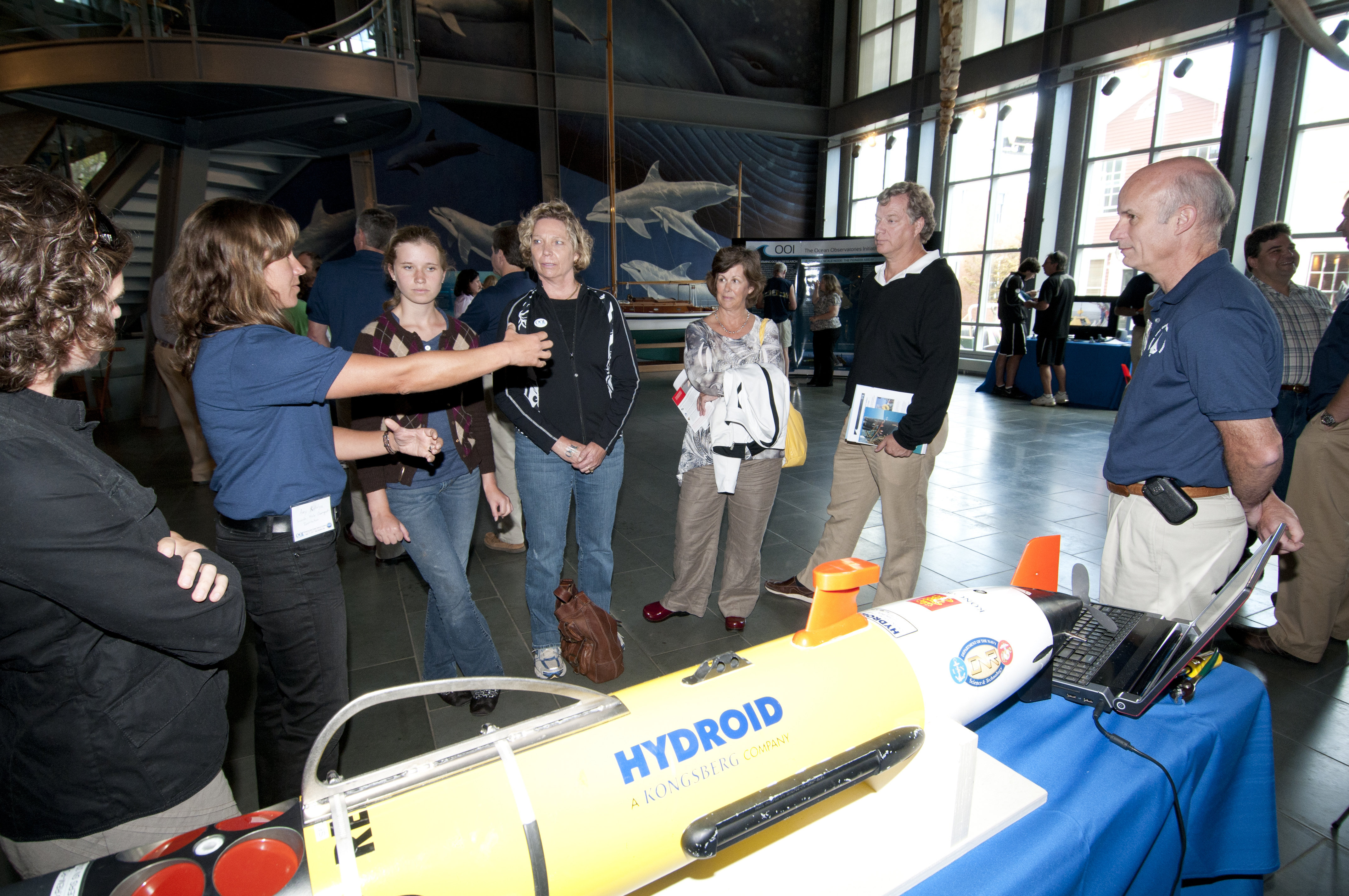 Amy Kukulya (second from left) and Al Pluddemann (right), both of Woods Hole Oceanographic Institution, discuss REMUS Autonomous Underwater Vehicle operations with visitors at an OOI community event at The New Bedford Whaling Museum. (Credit: Jayne Doucette, Woods Hole Oceanographic Institution)