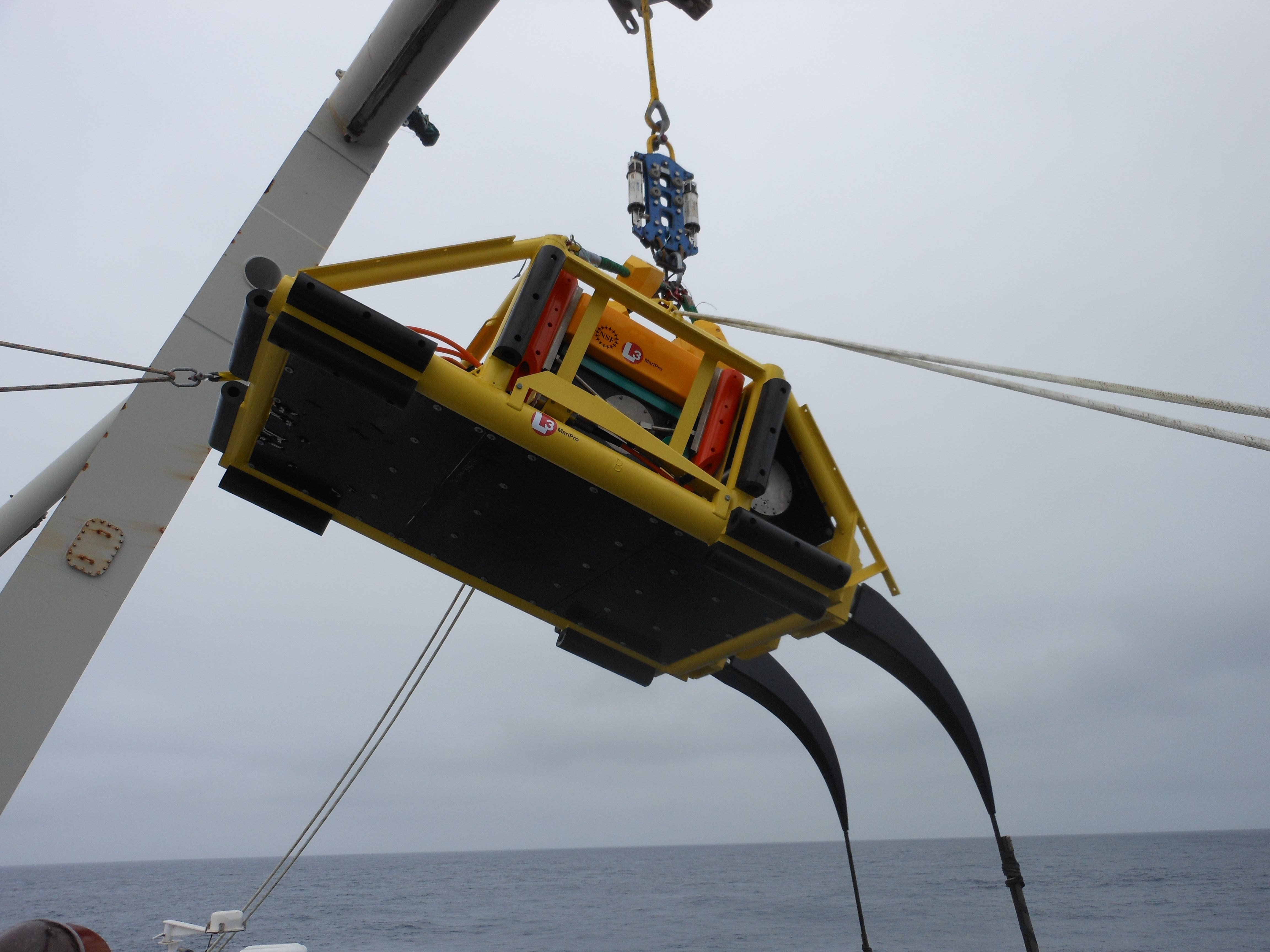 Node PN1A—the first node to be installed—shown here being launched from the back deck of the TE SubCom CS Dependable. Note the  black cable tails that curve down from the node on the right-hand side of the photo. The two ends of cable segments are spliced into the node at these tails. PN1A was deployed in deep water (2900 meters) and does not have a trawl-resistant frame.  Photo courtesy of L3-MariPro 