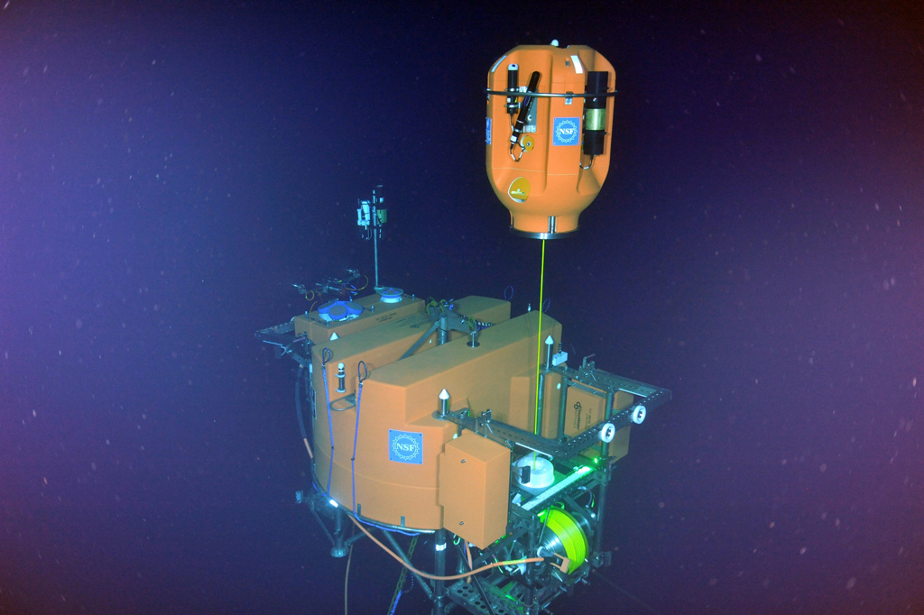 Profiling the Ocean - A first glimpse of the shallow winched profiler coming out of its docking station at the base of Axial Seamount. Photo Credit: NSF/OOI/UW/ISS; Dive R1842; V15.