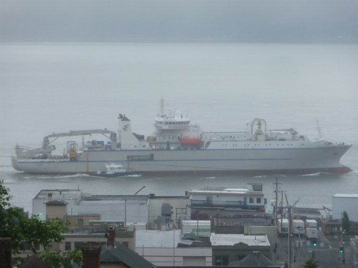 The OOI RSN Primary Node Installation operations had a mid-cruise port call in Portland, Oregon, for resupply and crew changes. Shown here is the TE SubCom CS Dependable passing by Astoria, Oregon, on August 2, 2012. The smaller vessel alongside is the pilot boat, Connor Foss, which transferred the Columbia River Pilot to and from the ship. Photo Courtesy of Scott McMullen, Oregon Fishermen's Cable Committee (OFCC)