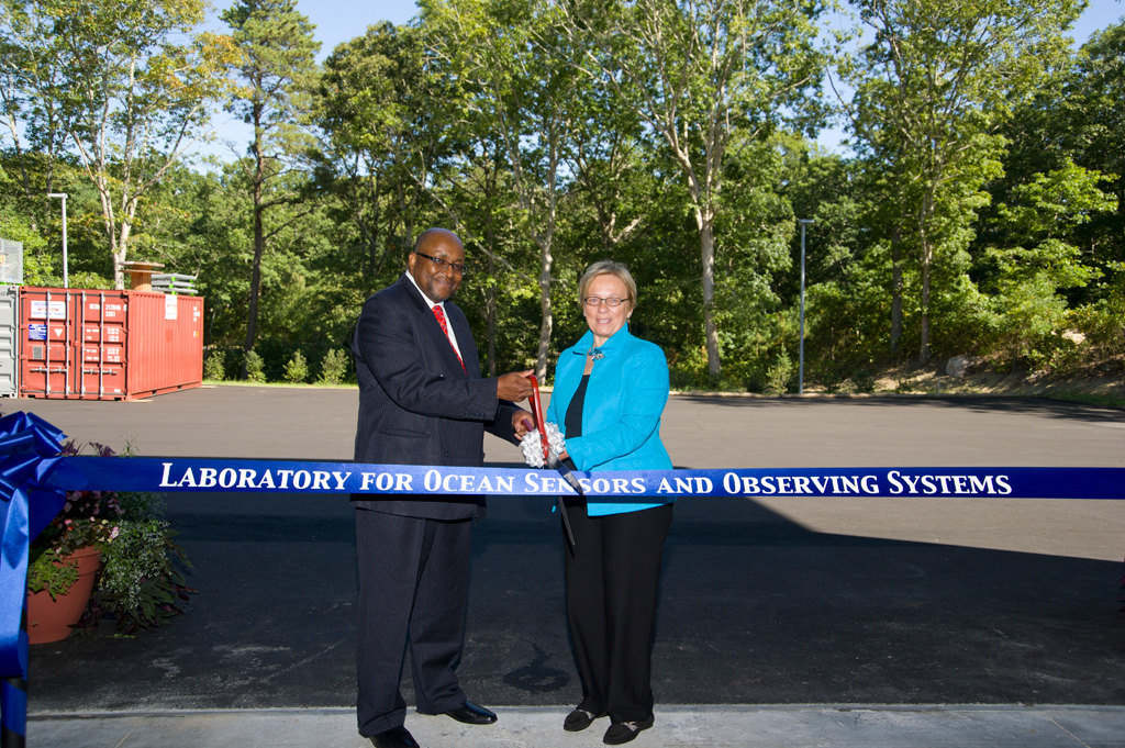 WHOI President and Director Susan Avery is joined by National Institute of Standards and Technology (NIST) Associate Director for Laboratory Programs and Principal Deputy Willie May at a dedication ceremony Sept. 20 for the new Laboratory for Ocean Sensors and Observing Systems. WHOI received an $8.1 million grant from NIST in 2010 to fund construction of the new scientific research facility. The 26,000-square-foot, “green”-designed building will provide space for several different groups creating long-term ocean observing systems, the largest of which is WHOI’s coastal and global scale nodes (CGSN) team of the OOI. The building is tailored to the needs of the team, including the central high bay, built to accommodate tall buoys and with a 10-ton capacity bridge crane for hoisting them. (Photo by Tom Kleindinst, Woods Hole Oceanographic Institution)