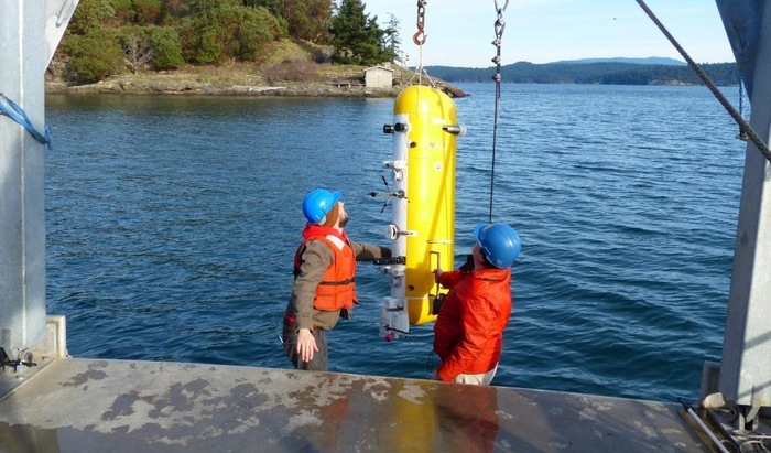 The Deep Profiler vehicle being installed on the mooring cable at the Friday Harbor test site. The FHL Pump House, which contains the power supply and other shore equipment, is shown in the background.