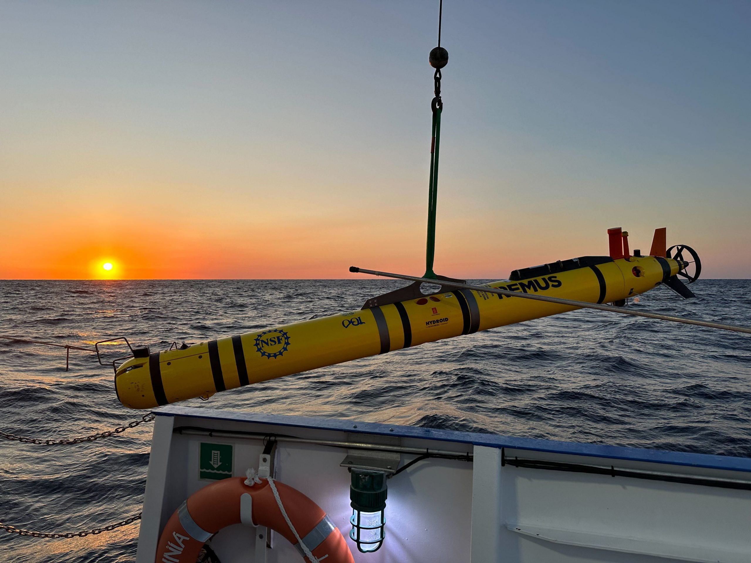 AUV deployment off ship with sunset