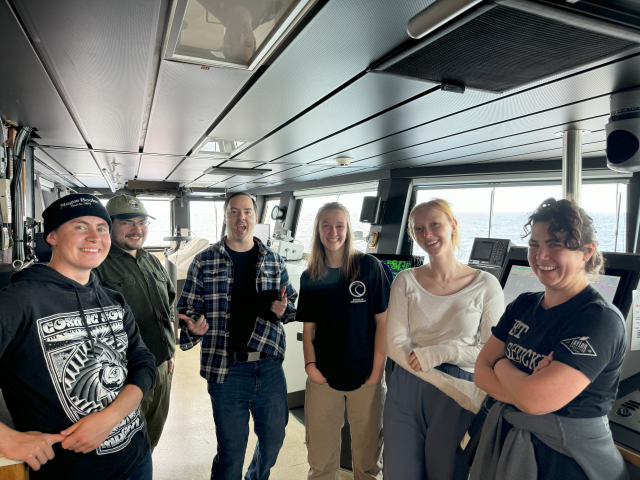 Visions students stand in group on the bridge of R/V Atlantis.