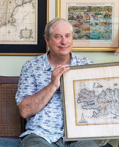 Glen smiles, holding one of his many maritime maps